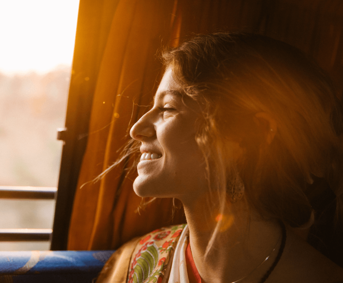 en kvinna som ler ut mot ett fönster
