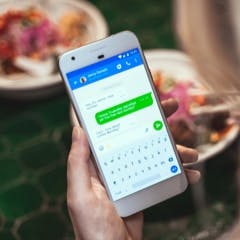 a phone showing an SMS conversation in the Truecaller app