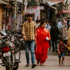 two people walking down a street in an Indian suburb